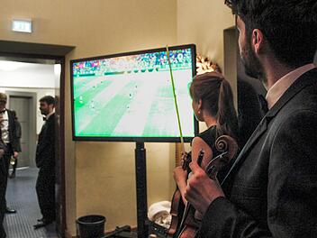 Geiger Thomas Reif (rechts) nutzt die Konzertpause, um ein paar Minuten Live-Fußball zu schauen. Borst