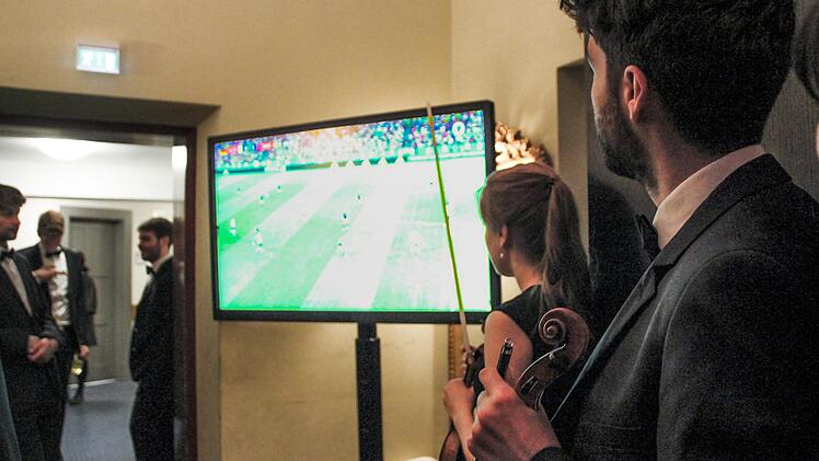 Geiger Thomas Reif (rechts) nutzt die Konzertpause, um ein paar Minuten Live-Fu&szlig;ball zu schauen. Borst