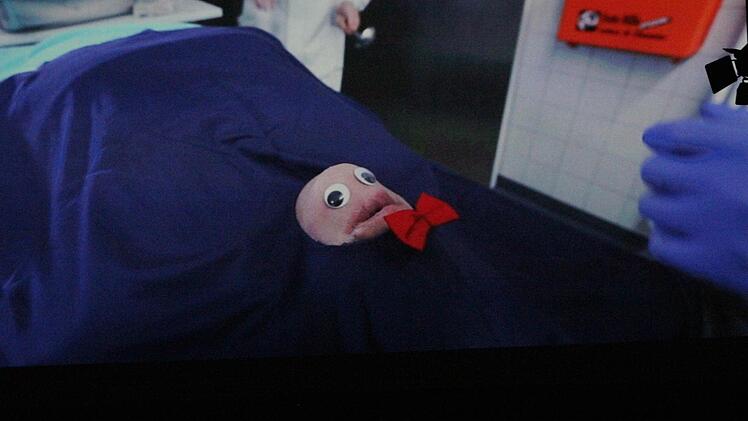 Gerichtsmediziner Axel Zuck (Michl Müller, man sieht nur die behandschuhten Hände) hat wohl etwas zu viel gekifft. Foto: Josef Hofbauer