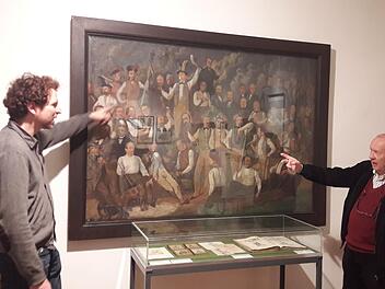Museumsleiter  Nicolas Zenzen und Stadtarchivar  Klaus-Dieter Guhling suchen und finden das Gesicht von Ignaz Bals im "Reichstruppenbild", das derzeit Bestandteil der Ausstellung "Bals + Bals  , Vater und Tochter" im Hennebergmuseum ist. Noch bis um 6. Januar  können die Arbeiten besichtigt werden.Hartmut Hessel