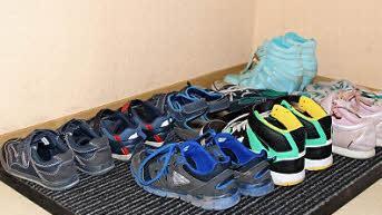 Die restliche Wohnung wirkt im Kontrast zur abgenutzten Küche ordentlich und sauber. Im Flur stehen die Schuhe aufgeräumt an der Haustür.