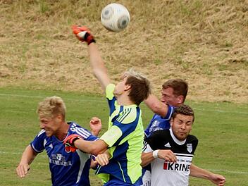 Der Sander Keeper Dominik Biemer (gelb-blaues Trikot) klärt per Faustabwehr vor seinem ehemaligen Teamkollegen und jetzigen Münnerstädter Stefan Nöthling (l.). Foto: Günther Geiling