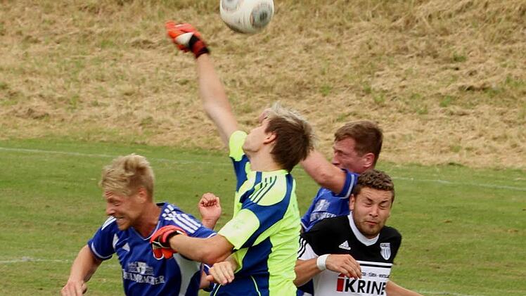 Der Sander Keeper Dominik Biemer (gelb-blaues Trikot) klärt per Faustabwehr vor seinem ehemaligen Teamkollegen und jetzigen Münnerstädter Stefan Nöthling (l.). Foto: Günther Geiling