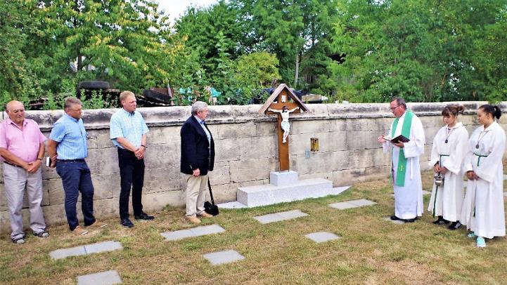 Pfarrer Hans-Michael Dinkel segnete die Urnenvasen-Grabanlage auf dem Neukenrother Friedhof. Mit auf dem Bild sind unter anderem Kirchenpfleger Peter Kratochvill (Dritter von links) sowie der Hobbykünstler Hubert Busse (Vierter von links). Foto: Gerd Fleischmann