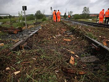 Bahnarbeiter arbeiten am 30.05.2016 in den Nähe von Lehrberg bei Ansbach (Bayern) an einer nach einer Überschwemmung nach einem Unwetter durch Erde und Baumreste blockierten Bahnstrecke. In der Nacht wurden zahlreiche Straßen und Keller überflutet und Erdrutsche blockierten Straßen. Foto: Daniel Karmann/dpa