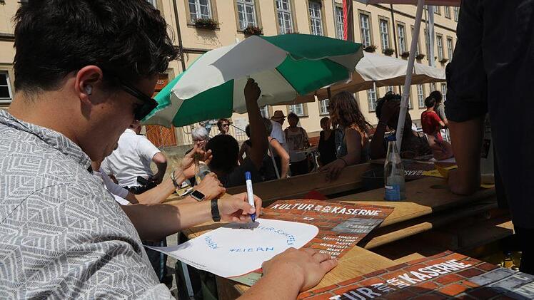 Andreas Klenk vom "Kontakt"-Team und weitere Kulturschaffende  machten sich zuletzt vor dem Rathaus in Bamberg für das soziokulturelle Zentrum  auf dem Lagarde-Gelände im Osten der Stadt stark.  Auf Plakaten beschrieben sie ihre Vorstellungen eines solchen Quartiers. Foto: Barbara Herbst