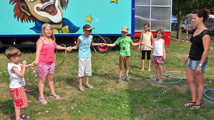 Nadine Lauenburger (rechts) vom Familien- und Projektcircus Lauenburger studiert mit einigen Kindern Darbietungen mit Hula-Hoop-Reifen ein. Foto: Ulrike Langer