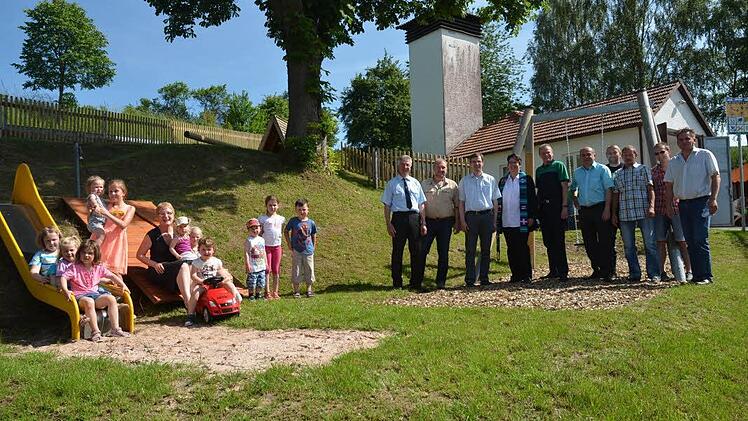 Groß und Klein, Ehrengäste und Idealisten der Feuerwehr freuen sich über die Eröffnung des neu gestalteten Spielplatzes in Wötzelsdorf. Pfarrerin Alina Ellgring (Siebente von rechts) sprach den Segen.  Foto: Hofmann