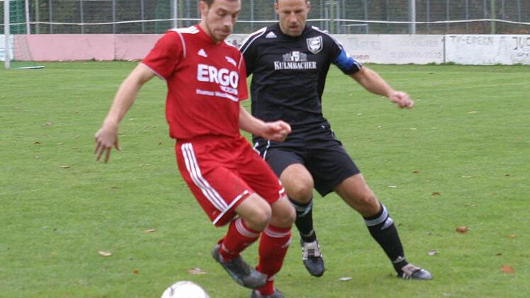 Der Eberner Libero Beck (rechtsm dunkles Trikot) attakiert Gästeangreifer Feyler.
