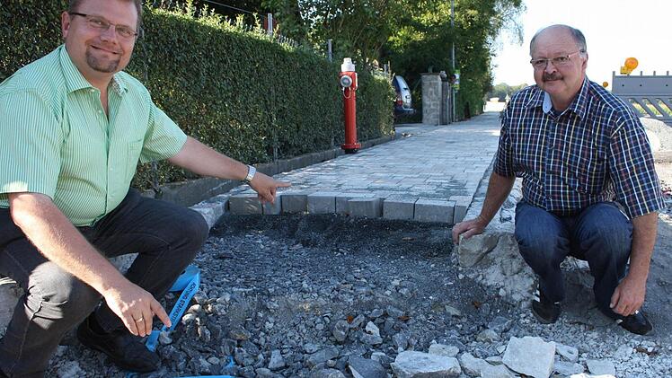 So soll der Gehsteig durch ganz Reupelsdorf führen: Mindestens anderthalb Meter breit, beidseitig und gepflastert. Bürgermeister Werner Knaier und Oswald Bader zeigen schon einmal die ersten Meter.