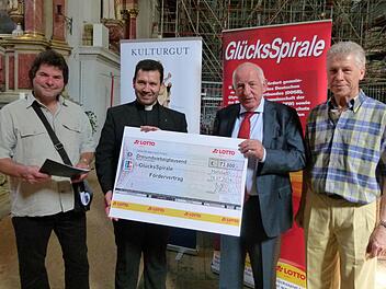 Vor dem Gerüst im Chorraum überreichten Uwe Franke (l.) und Hubert Hennes (2.v.r.) an Pfarrer Anton Heinz und Kirchenpfleger Georg Koch (r.) den Förderscheck.Fotos: Marion Krüger-Hundrup