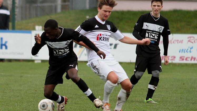 Dem Sander Sebastian Götz wird hier in seinem Sturmlauf von dem Kitzinger Bakare Ahmed (links) der Ball abgelaufen.