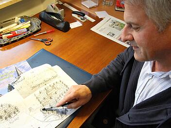 Hans Schaub  beugt sich über  die historische Jagdkarte mit dem Kreuzberg   aus dem Jahr 1740. Mathias Erlwein