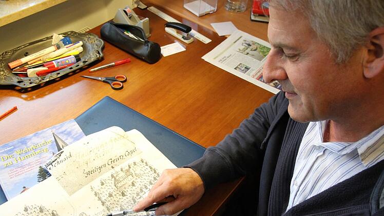 Hans Schaub  beugt sich über  die historische Jagdkarte mit dem Kreuzberg   aus dem Jahr 1740. Mathias Erlwein