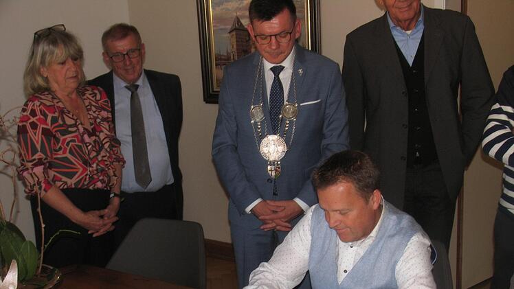 Van Miert unterzeichnet den aktuellen Eintrag ins goldene Buch. Foto: Hilmar Ruppert
