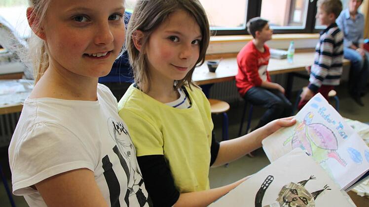 Alles nach Plan: Sabine und Marie zeigen Skizzen ihrer Zeitungs-Tiere.