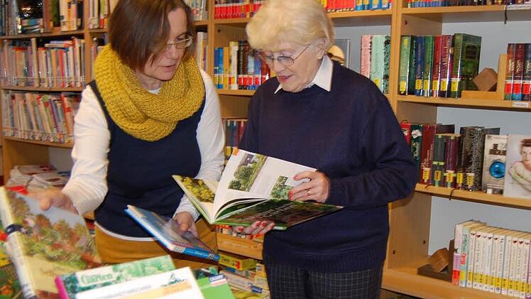 Bücherei-Leiterin Barbara Seufert (links) sortiert mit Thea Hartl den Büchertisch. Foto: Sigismund von Dobschütz