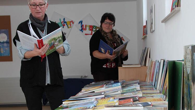 Von wegen Däumchen drehen: Eva-Maria Trutz-Özbe (links) und Hannelore Roth nutzen den Tag, um eine Bücherausstelllung aufzubauen. Foto: Ulrike Müller