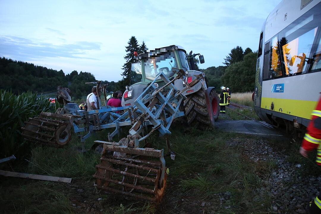 Traktor kracht in Zug - Glücklicherweise lediglich Zuginsassin und Traktorfahrer verletzt – Kollision erfolgte an unbeschranktem Bahnübergang – Unfallursache noch unklar – Großaufgebot an Rettungskräften alarmiert
