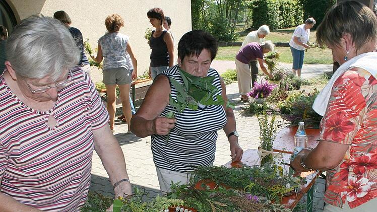 Die  Gartenvereins-Frauen beim  Würzbüschelbinden. Rechts die Vorsitzende Elisabeth Liebl. Foto: Mathias Erlwein