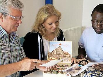 Hans-Peter Hörrlein und seine Tochter Christine betrachten die Bilder von der restaurierten Schule, die Christian Bouwé aus Kamerun mitgebracht hat. Foto: Johanna Blum