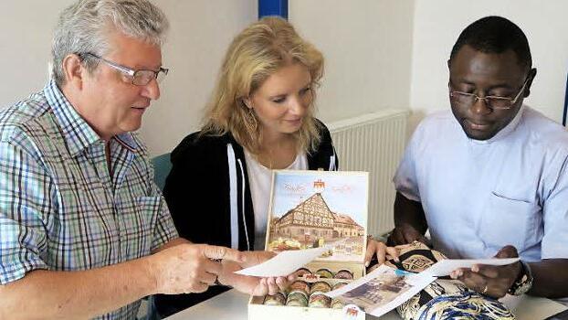 Hans-Peter Hörrlein und seine Tochter Christine betrachten die Bilder von der restaurierten Schule, die Christian Bouwé aus Kamerun mitgebracht hat. Foto: Johanna Blum