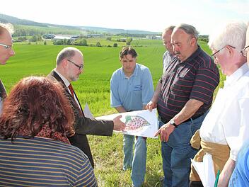 Vorne der Plan, im Hintergrund das Gelände: Bürgermeister Robert Herrmann erklärte den Mitgliedern des Bauauschusses, wie der fast 13 Hektar große Acker in Richtung Uniwell in den nächsten Jahren sukzessive erschlossen werden soll. Foto: Ralf Kestel