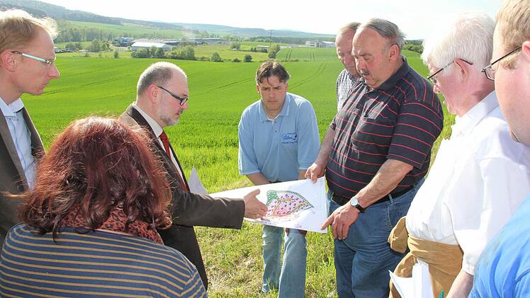 Vorne der Plan, im Hintergrund das Gelände: Bürgermeister Robert Herrmann erklärte den Mitgliedern des Bauauschusses, wie der fast 13 Hektar große Acker in Richtung Uniwell in den nächsten Jahren sukzessive erschlossen werden soll. Foto: Ralf Kestel