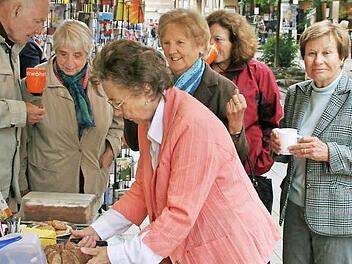 Charlotte Fries (ganz rechts) bietet Kuchen und fairen Kaffee vor dem Weltladen an.  Foto: Werner Vogel