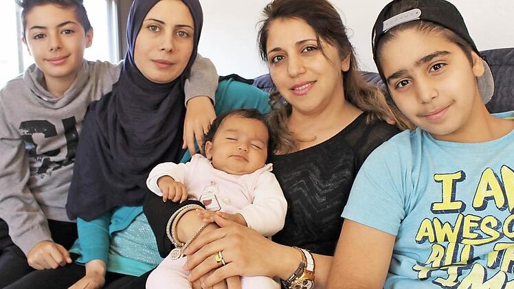 Wie in einer Großfamilie: Hazar Aboukaf (2. von rechts) mit ihrem Sohn Faris Danoura (rechts) und dem Baby Fatima sowie Lina Balhous mit Sohn Ismail Hamada (links). Die Mutter des Babys wollte nicht mit auf das Bild. Gemeinsam unterstützen die beiden erfahrenen Frauen die frischgebackene Mutter Maria.  Foto: Julia Raab