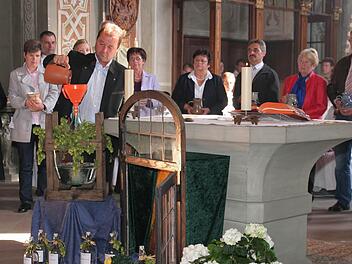 Die Vertreter der drei Pfarrgemeinden sind mit ihren Wasserkrügen um den Altar aufgestellt.  Wolfgang Lurati  schüttet sein Gefäß  während des symbolischen Aktes zur Errichtung der Pfarreiengemeinschaft in den großen Wasserballon.  Fotos: db