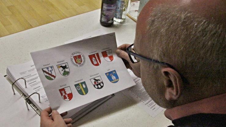 Den Entwurf von Gemeindewappen von Kreisheimatpfleger Günter Lipp für die Ortsteile Junkersdorf, Lohr und Herbelsdorf billigte das Gremium. Hier wirft Gemeinderat Markus Oppelt einen Blick auf die Wappen der Gemeinde. Helmut Will