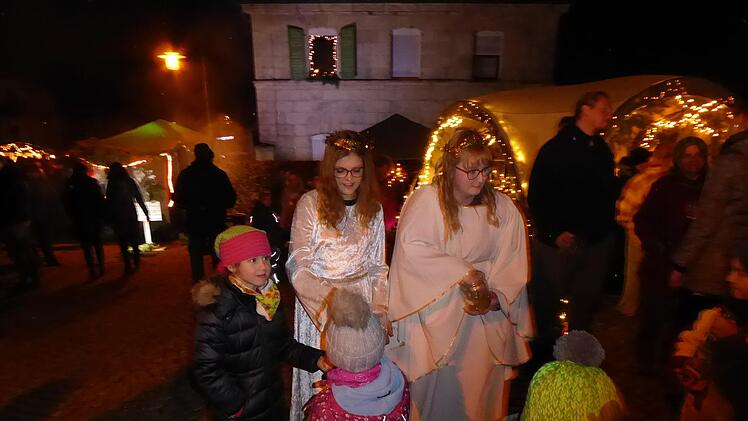 Die Weilersbacher Weihnachtsengel Jana und Lucy mit den  Kindern am Markt Foto: Heidi Amon