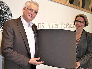 Der neue Vorstand Michael Ocker und Vorstandsvorsitzende Sibylla Naumann präsentieren den Stoff, den die Kneitz AG für die Lkw-Sitze der Firma MAN produziert.