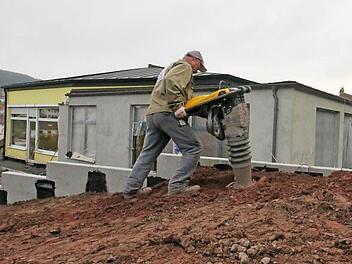 Ein Arbeiter mit Rüttelplatte am Kindergarten in Winkels. Foto: Benedikt Borst