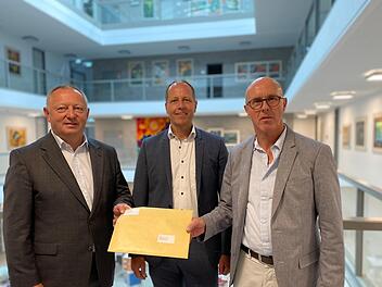 Trimbergs Ortssprecher Günter Betzen (rechts) und Bürgermeister Johannes Krumm (Mitte) übergeben Landrat Thomas Bold eine Unterschriftenliste gegen die Geschwindigkeitserhöhung. Foto: Angelika Despang