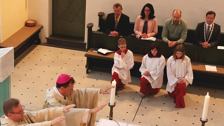 Pfarrer und Bischof erteilen den Segen.