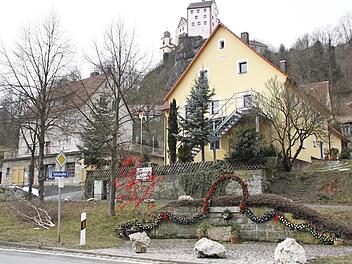Der Schützenbrunnen als Osterbrunnen (mit Burg Egloffstein im Hintergrund)  Foto: Reinhard Löwisch