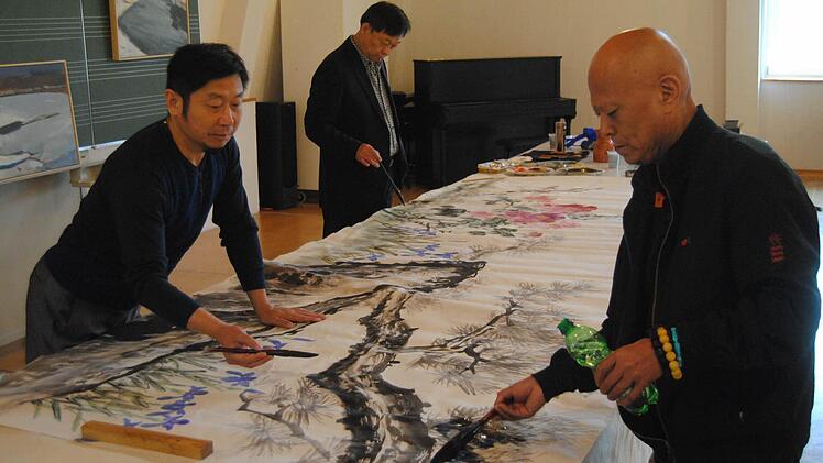 Zeitgenössische Malerei: Wang Linhong, Liu Jihong und Ma Jun (von links) vereinen ihre Stile auf einem großen Wandbild. Fotos: Wolfgang Dünnebier