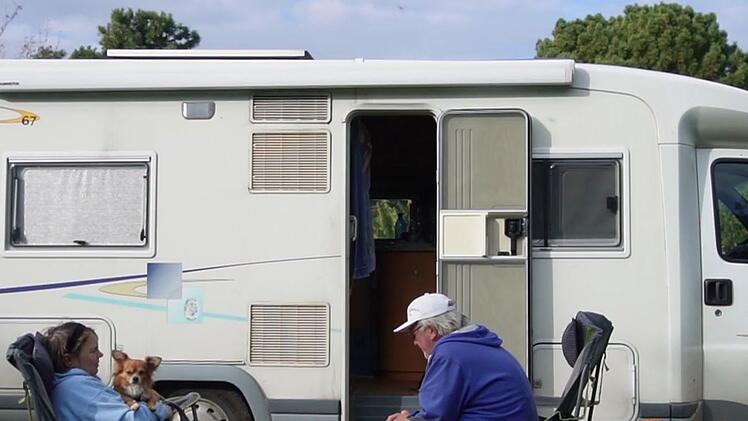 Zuhause auf Zeit: Petra, Struppi und Bernd vor ihrem Wohnmobil.