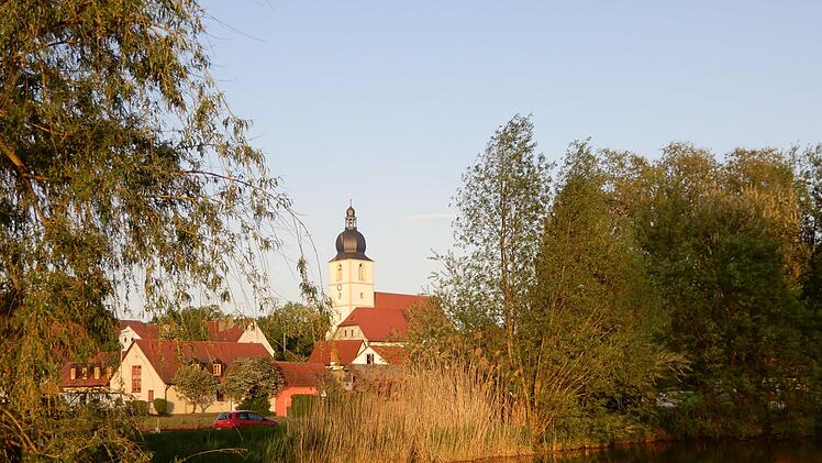 Blick über den Dorfsee: Die Rentweinsdorfer Dreieinigkeitskirche, das größte evangelische Gotteshaus der Umgegend, bildet den Mittelpunkt des Ortes. Foto: Horst Schneider