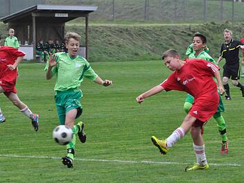 Dieses ist der erste Streich: Raphael Höchemer (rotes Trikot) erzielt in dieser Szene den Führungstreffer für die SG Wollbach. Zu spät kommt der Rettungsversuch vom Großbardorfer Nicola Feder. Foto: Anja Schmitt