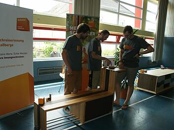 Mit seiner Garderobenbank gewann Moritz Werb den Wettbewerb "Die schöne Form". Seinen bisherigen Mit-Azubis Ulrich Spengler und Johannes Stretz (von rechts) erläuterte er die handwerklichen Details.