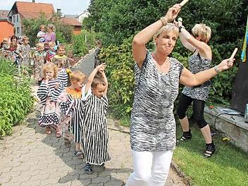 Angeführt von Leiterin Anett Korn zogen die Jungen und Mädchen des Kindergartens Schneckenlohe in afrikanischer Kleidung auf den Festplatz.  Foto: Herbert Fischer