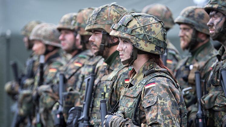 Eine deutsche Bundeswehr-Soldatin steht mit ihrem Kameraden beim von der Bundeswehr angeführten Nato-Bataillon auf dem Militärstützpunkt in Rukla/Litauen. Im Zuge der Aufrüstung der Nato wird die Bundeswehr aller Voraussicht nach ein neues Planungs- und Führungszentrum für Truppen- und Materialtransporte aufbauen. Foto: Bernd von Jutrczenka/dpa