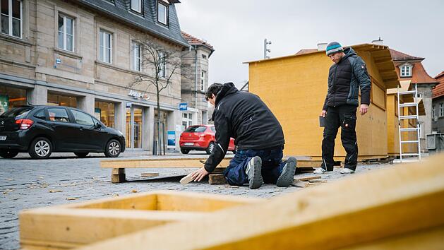 Mit vereinten Kr&auml;ften: Neun Helfer vom Verein Kronacherleben bauten am Samstag schon einmal die Holzh&uuml;tten auf, in die an den vier Adventswochenenden die H&auml;ndler einziehen werden. Am Montag wurden dann die Stromleitungen verlegt. Foto: Marian Hamacher