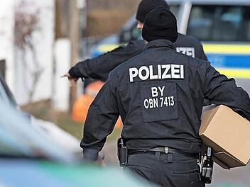 Polizisten sichern Material, das in einer groß angelegten Durchsuchungsaktion bei so genannten Reichsbürgern in mehreren Bundesländern sichergestellt wurde. Das Bild zeigt den Einsatz vom Dienstag (7. Februar) vor einem Wohnhaus im oberbayerischen Pliening, wo der selbst ernannte Bundesstaat Bayern quasi seinen Verwaltungssitz hat. Foto: Matthias Balk/dpa