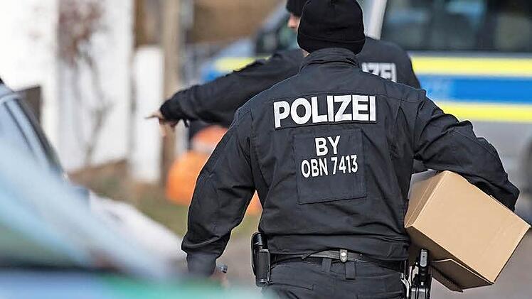 Polizisten sichern Material, das in einer groß angelegten Durchsuchungsaktion bei so genannten Reichsbürgern in mehreren Bundesländern sichergestellt wurde. Das Bild zeigt den Einsatz vom Dienstag (7. Februar) vor einem Wohnhaus im oberbayerischen Pliening, wo der selbst ernannte Bundesstaat Bayern quasi seinen Verwaltungssitz hat. Foto: Matthias Balk/dpa