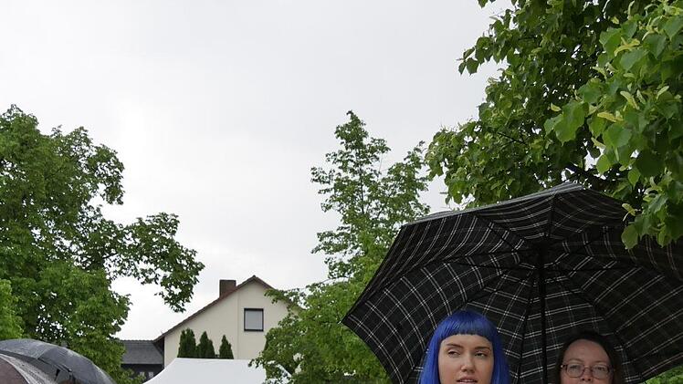 Und im Stehen und beim Flanieren leisteten Regenschirme beste Begleitung. Foto: Manja von Nida