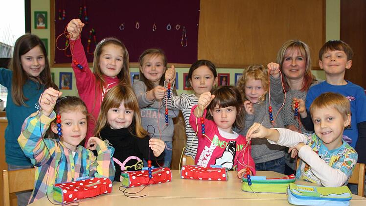 Perlensammler: Die zehn Vorschulkinder in der Gruppe von Cathleen Mende (hinten rechts) bereiten sich Schritt für Schritt auf die Grundschule vor. Für Erfolge im Kindergarten gibt es rote, bei Schulbesuchen blaue Perlen. Wenn die Schnur voll ist, kann die Schule los gehen. Fotos: Ralf Ruppert